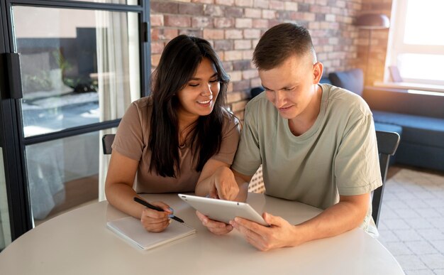 Homem e mulher fazendo lista de compras com tablet