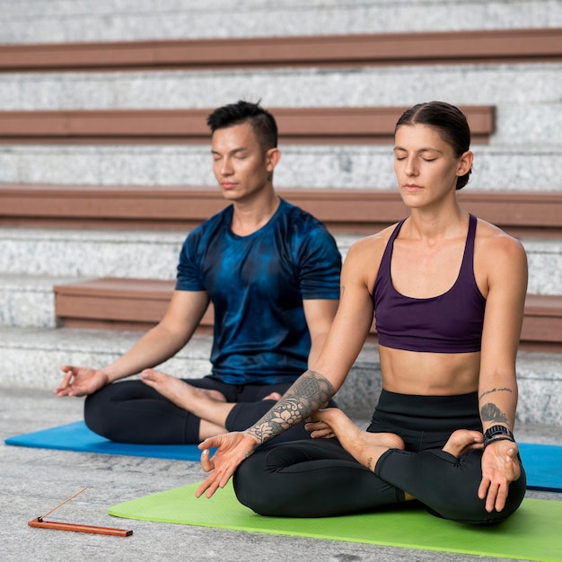 Homem e mulher fazendo treinamento de ioga juntos