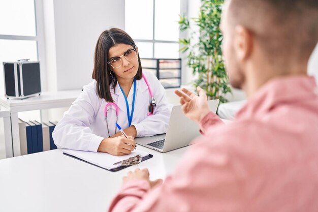 Homem e mulher médico e paciente tendo consulta médica na clínica