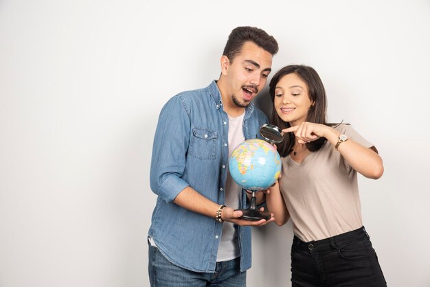 Homem e mulher olhando na globo em branco.