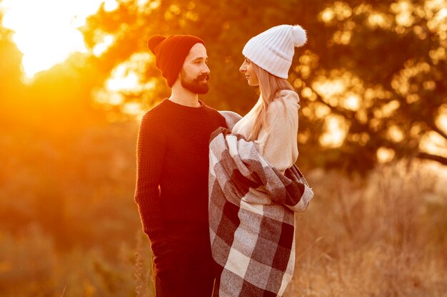 Homem e mulher olhando um ao outro ao pôr do sol