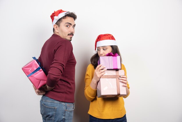 Homem e mulher posando com presentes de Natal.