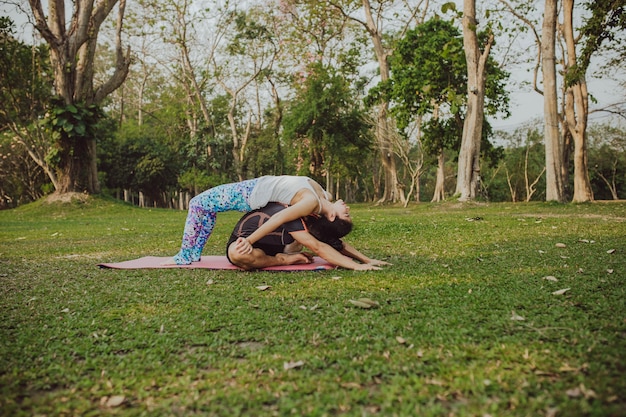 Foto grátis homem e mulher praticando ioga no parque