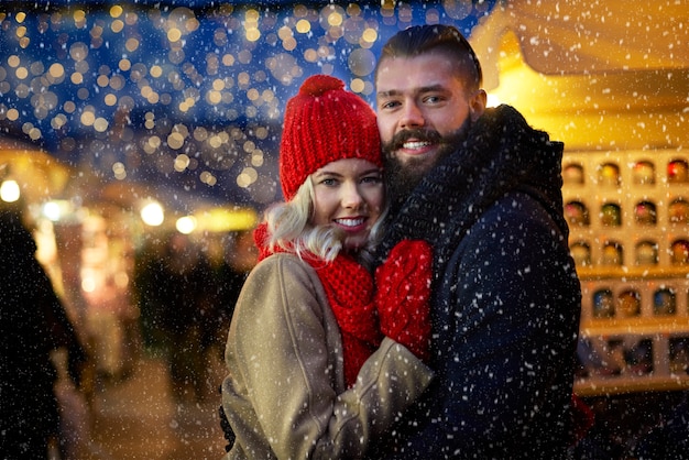 Homem e mulher rodeados de flocos de neve