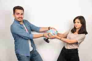 Foto grátis homem e mulher segurando um globo em branco.