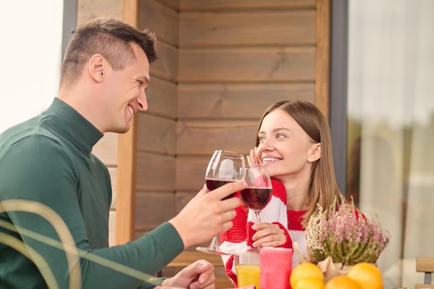 Foto grátis homem e mulher tocando taças de vinho olhando um para o outro