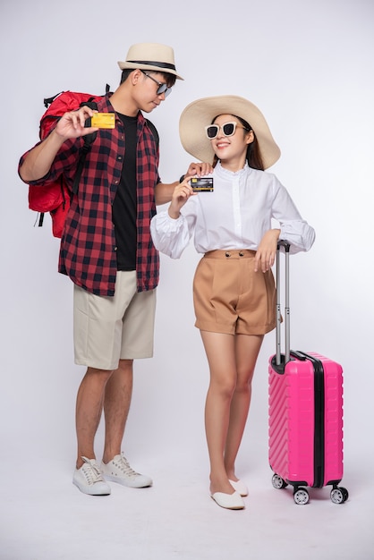 Homem e mulher vestidos de óculos para viajar com malas