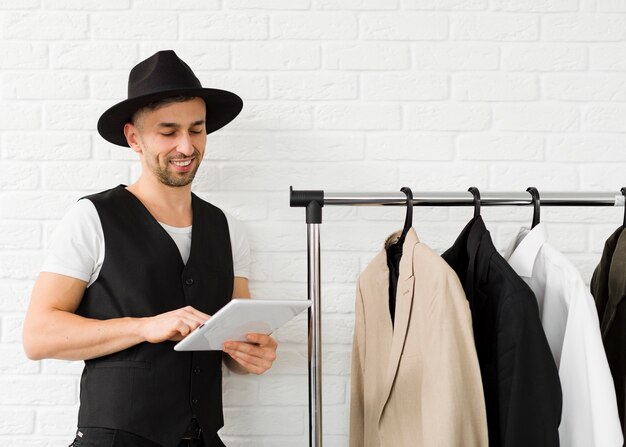 Homem elegante de chapéu usando o tablet