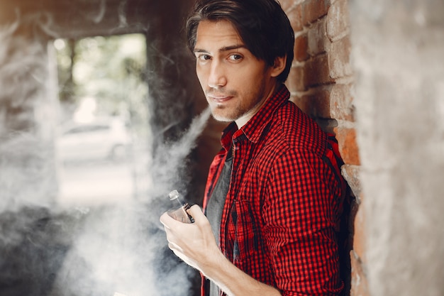 Foto grátis homem elegante e elegante em uma cidade com vape