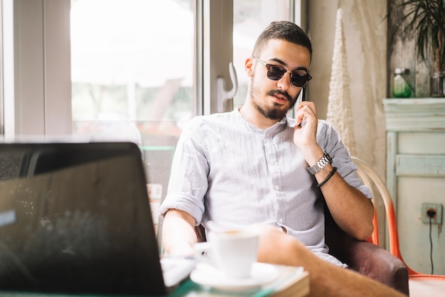 Homem elegante falando no telefone no café