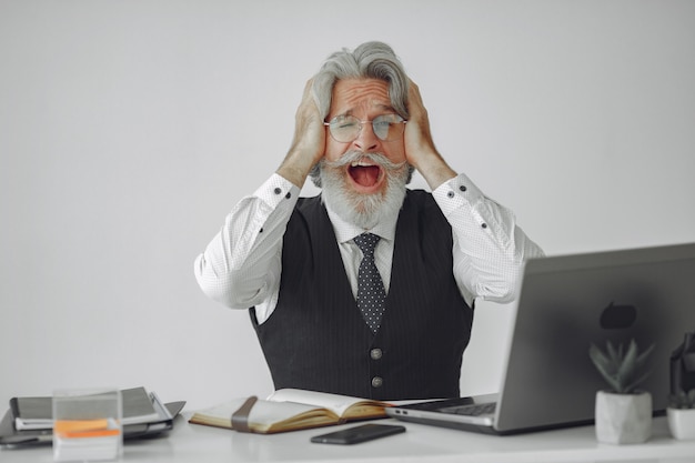 Foto grátis homem elegante no escritório. empresário de camisa branca. homem trabalha com laptop.