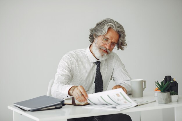 Homem elegante no escritório. Empresário de camisa branca. O homem trabalha com documentos.