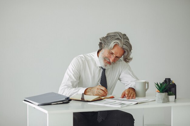 Homem elegante no escritório. Empresário de camisa branca. O homem trabalha com documentos.