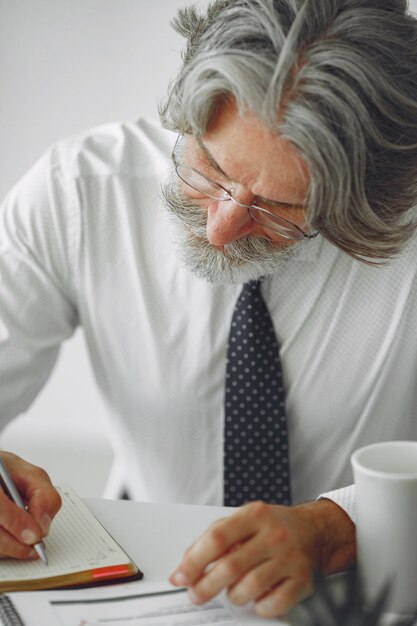 Homem elegante no escritório. Empresário de camisa branca. O homem trabalha com documentos.