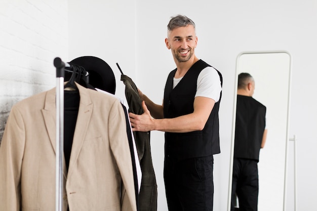 Homem elegante, segurando as roupas e desviar o olhar