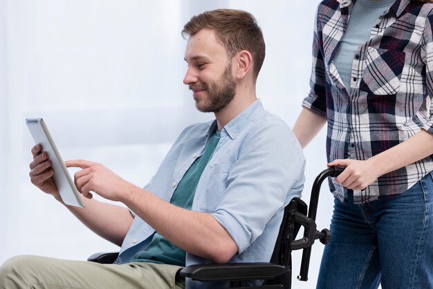 Homem em cadeira de rodas com tablet