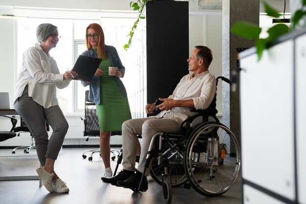 Homem em cadeira de rodas tendo um trabalho de escritório inclusivo