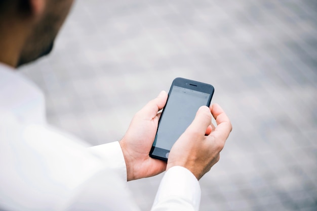 Homem em camisa segurando smartphone