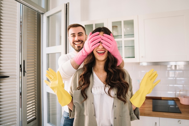 Homem em luvas fechando olhos para namorada