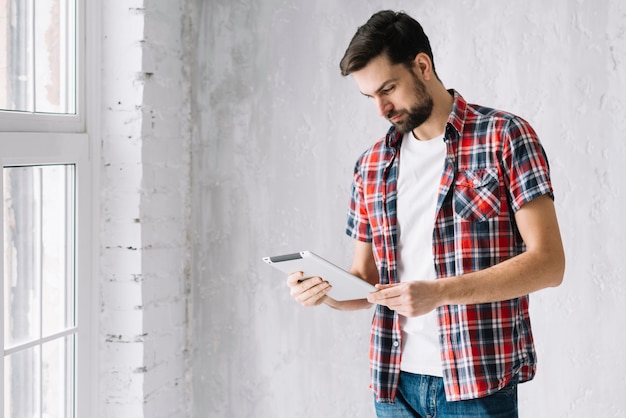 Homem em pé usando tablet