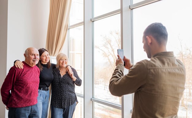 Homem em plano médio tirando fotos com o telefone