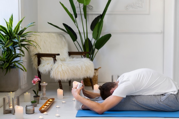 Homem em plena ação fazendo ioga no tapete