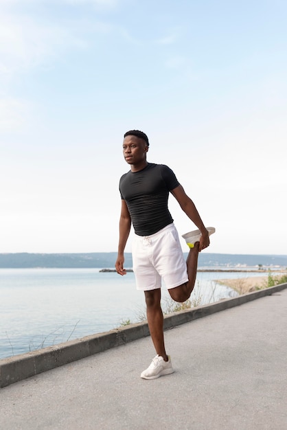 Homem em roupas esportivas fazendo exercícios ao ar livre