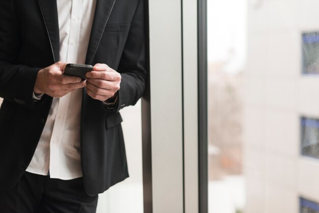 Homem em traje com smartphone