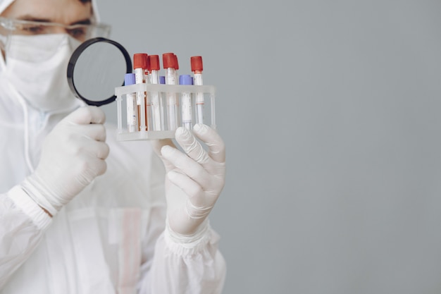 Foto grátis homem em traje de proteção e óculos trabalhando no laboratório