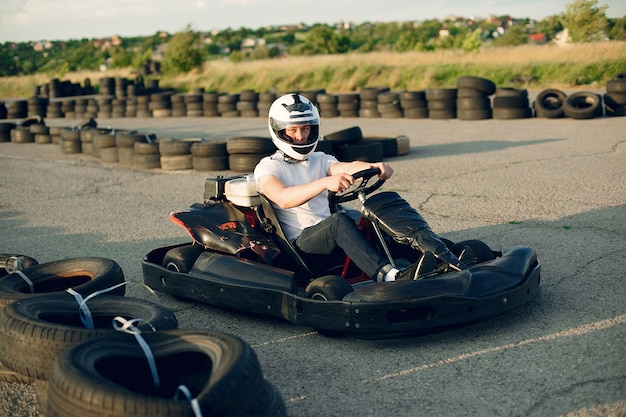 Homem em um circuito de kart com um carro