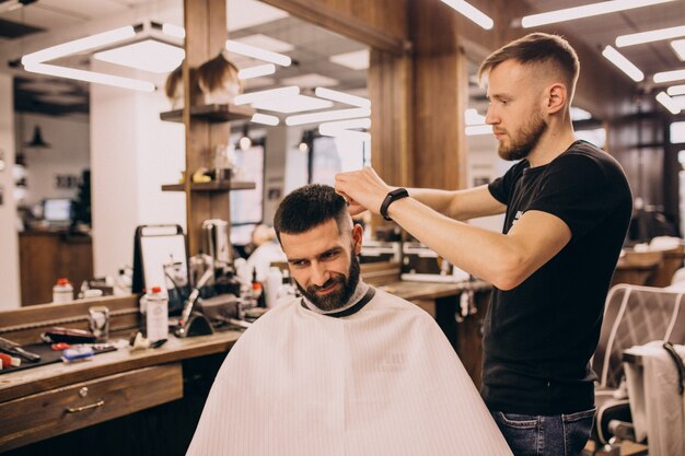 Homem em um salão de barbearia, fazendo o corte de cabelo e barba