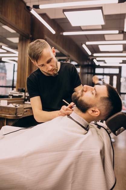 Homem em um salão de barbearia, fazendo o corte de cabelo e barba