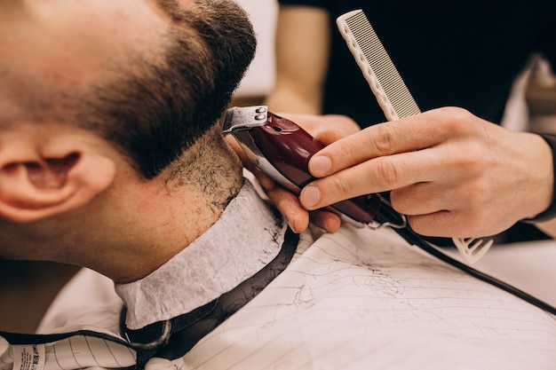 Homem em um salão de barbearia, fazendo o corte de cabelo e barba