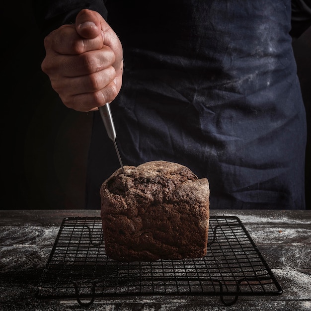 Foto grátis homem enfiando uma faca no pão