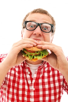 Homem engraçado em copos comendo hambúrguer isolado no branco