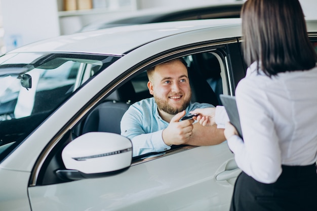 Homem escolhendo um carro em um salão de carros