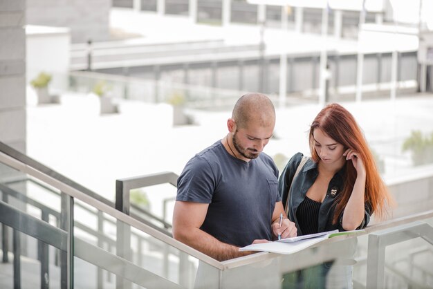 Homem escrevendo em documentos para mulher