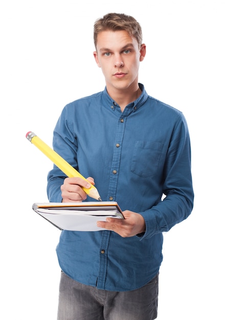 Homem escrevendo em um caderno com uma pena gigante