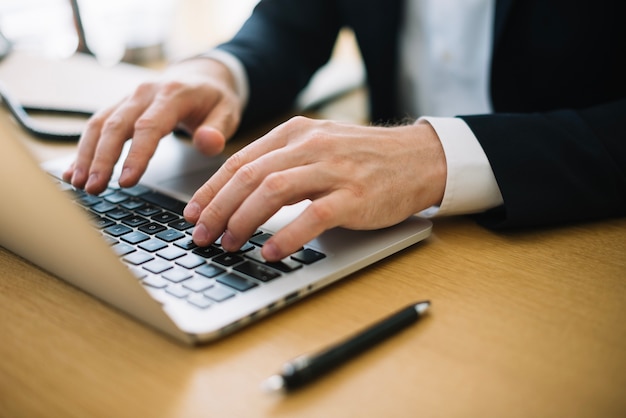 Homem escrevendo no laptop no escritório