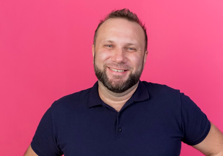 Foto grátis homem eslavo adulto feliz olhando e sorrindo isolado na parede rosa