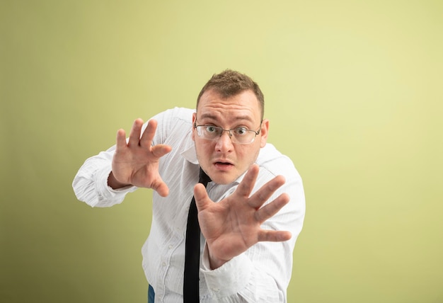 Homem eslavo adulto impressionado de óculos e gravata, olhando para a câmera, estendendo as mãos e gesticulando não isolado em fundo verde oliva com espaço de cópia