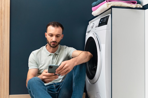 Homem esperando a máquina de lavar terminar seu programa