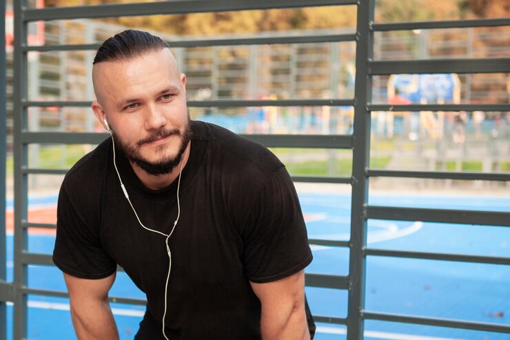 Foto grátis homem esportivo com fones de ouvido, olhando para longe
