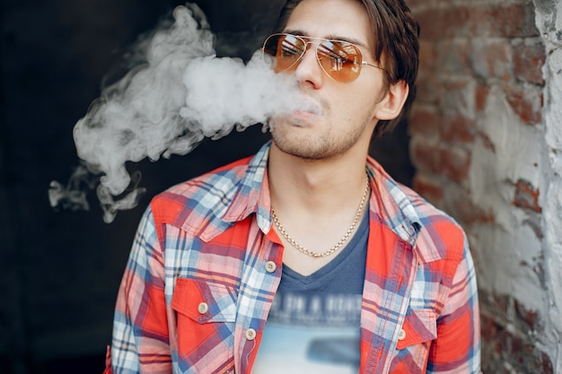 Foto grátis homem estiloso e elegante em uma cidade com vape