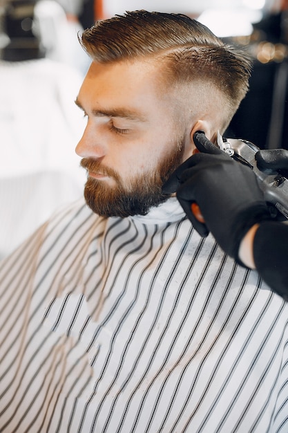 Foto grátis homem estiloso sentado em uma barbearia