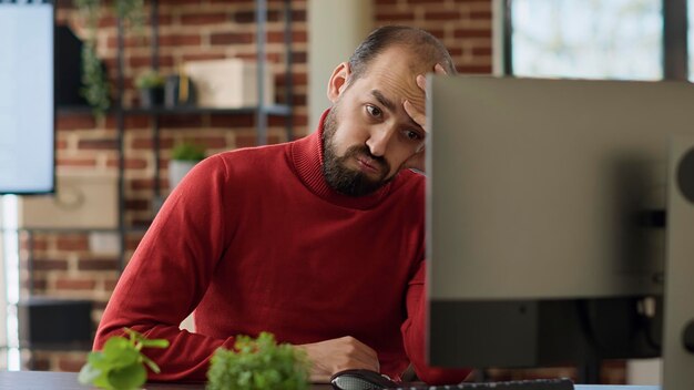 Homem estressado exausto trabalhando em análise de marketing, tentando criar desenvolvimento financeiro. Empregado se sentindo sobrecarregado e frustrado com o trabalho da empresa de inicialização, estatísticas de comércio eletrônico.