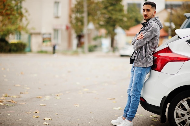 Foto grátis homem estudante kuwaitiano usa no hoodie stand perto do carro