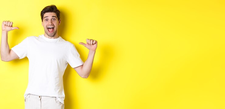Foto grátis homem excitado olhando feliz apontando para si mesmo com espanto em pé sobre fundo amarelo