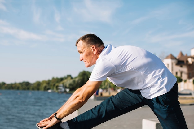 Homem exercitando perto de um lago