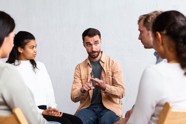 Foto grátis homem explicando seus problemas em uma sessão de terapia de grupo